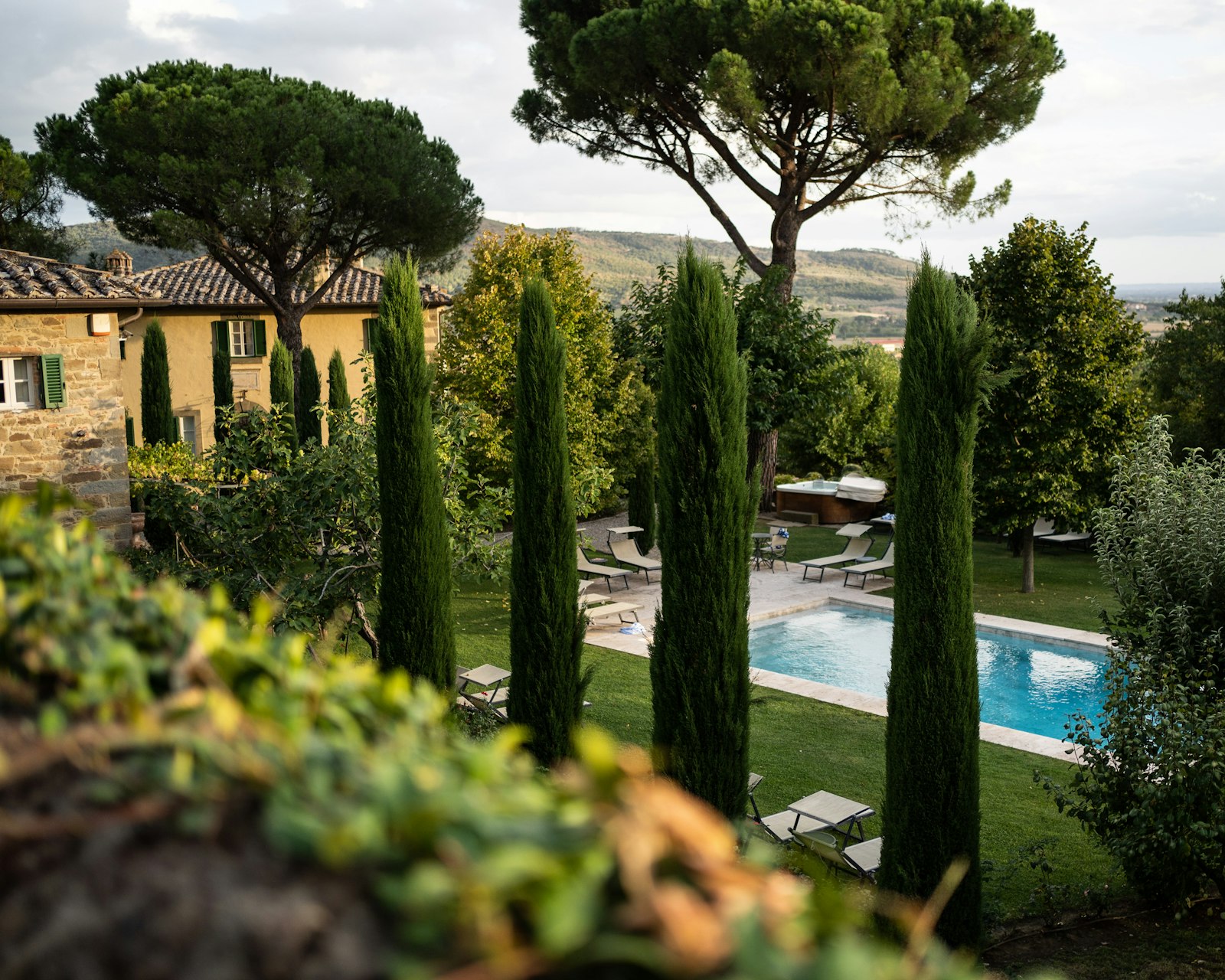 A Tuscan villa with a private pool framed by tall cypress trees